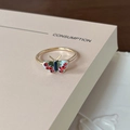 Detailed macro shot of a gold butterfly ring with teal enamel and red rhinestones - Red Diamond Green Butterfly