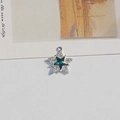 Close-up of a star-shaped pendant with dark green gemstone and pavé white rhinestones - Green Five-point Star
