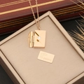 Detailed view of rose gold envelope locket with engraved 'Te quiero' metal card insert - Te quiero Engraved / Rose Gold