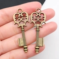 Vintage bronze alloy heart-shaped key charms held in hand for jewelry DIY projects - Antique Bronze Key 17x48mm