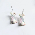 Close-up of Easter bunny earrings with plaid pattern and white fluffy pompom tail - Rainbow Grid