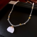 Detail of glass beaded necklace with large translucent white gemstone pendant - Gold and White Color Matching