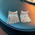 Detail of silver chain tassel earrings with round metal discs on green leather stand - Disc Tassel Style / Silver