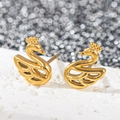 Vue macro de boucles d'oreilles cygne en acier inoxydable doré 18k sur fond scintillant - Cygne