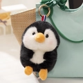 Cute plush penguin pendant keychain with ribbon detail on a light green backpack - Black Penguin
