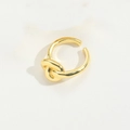 Gedetailleerde close-up van gouden knoopontwerp op een verstelbare open ring - Spiraal Stijl