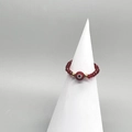 Macro shot of red beaded elastic ring featuring a central evil eye charm on a white stand - Adult Diameter 17-18mm / Red-Gold