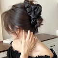 Elegante grote zwarte bloem haarklem gestyled op een knotje van een model - 3D Bloem Stijl / Zwart