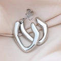 Detailed view of silver U-shaped geometric earrings on elegant champagne silk fabric - Smooth Irregular / Silver
