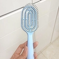 Flexible hellblaue Skelettbürste mit ergonomischem Griff für Kopfhautmassage - Stehend Klein Blau