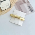 Polished gold geometric twisted hair clip on white display card for elegant ponytail styling - Large Twisted Gold