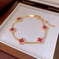 Macro shot of gold plated bracelet with five red zircon clover charms on a jewelry box - Gold - Rose Red - Real Gold Plated