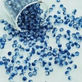 Detailed view of 6mm blue and white marble pattern glass beads pouring onto white fabric - 6mm / Ink Blue