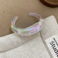 Macro shot of iridescent C-shaped bangle with ribbed texture on studio background - Iridescent - Coarse Texture