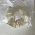 Detailaufnahme von cremeweißem Haargummi mit geraffter Textur aus Seersucker-Stoff - Creme
