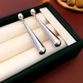 Detail von silbernen Tropfenohrringen mit Metallic-Finish in einer Premium-Geschenkbox - Wassertropfen-Ohrhänger / Silber