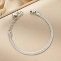 Polished silver stainless steel snake chain bracelet with heart pendant on beige background - Bracelet / Steel