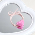 Pink heart-shaped elastic hair tie displayed on a white vintage heart mirror - Heart / Rose Red