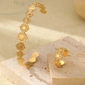 Detailed view of 18K gold plated stainless steel cuff bracelet and ring set on stone base - Disk Style