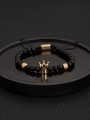 Detailed macro view of black beaded crown bracelet with adjustable cord on a tray - Black Gold Crown With Black Stone Bracelet