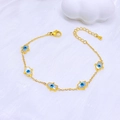 Gold Hamsa Hand bracelet with blue evil eye charms on elegant white silk background - Hamsa Hand