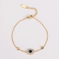 Macro view of gold stainless steel bracelet with blue evil eye and zircon details - Gold