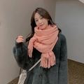 Pink cashmere blend wool scarf with fringe trim worn by a model in a studio setting - Orange