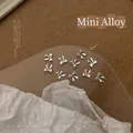 Λεπτομερής λήψη ασημένιων φιόγκων 5x5,5mm για διακόσμηση νυχιών και χειροτεχνία DIY - XY-549 Μίνι Φιόγκος Στυλ 2 5x5.5mm Λευκό K