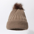 Detail of dark brown chunky knit beanie featuring a fluffy matching faux fur pom-pom - Brown