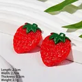 Vue détaillée d'un accessoire cheveux fraise rouge avec feuilles vertes et fini brillant - Fraise