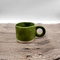 Minimalist green speckled ceramic mug with round handle on a wavy light wood surface - 250ML / Green