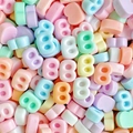 Macro-opname van kleurrijke B-vormige harsbedeltjes voor DIY-haarspelden en telefoonhoesjes - Letter B