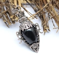 Macro view of gothic copper pendant necklace featuring black stone and filigree - Obsidian