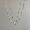 Detail of double-layer necklace featuring white pearls and a crystal-encrusted cylinder - Double Layer Pearl White Zirconia Ball Necklace