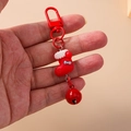 Close-up of a red Christmas stocking keychain with blue bow and matching metal bell - Red and White Enamel Christmas Sock