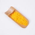 Artificial yellow rice grains for decoration presented on a small bamboo scoop - Orange Rice (500g)