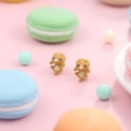 Cute brown triceratops cartoon stud earrings for women on a soft pink background - Neon Yellow
