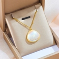 Golden titanium shell necklace with iridescent pearl inlay on a luxury jewelry cushion - Gold Shell Style (C312)