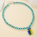 Detail of beaded necklace with blue glass beads and a colorful tropical fish pendant - D1663-1 (Blue Brown Beads Yellow Blue Fish)
