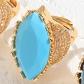 Macro shot of gold ring with large marquise turquoise stone and zircon embellishments - Adjustable Open / Blue Turquoise