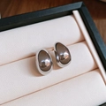 Macro shot of silver teardrop stud earrings with a high-polished mirror finish in a box - 18# Silver Needle Oval Bean Waterdrop Studs