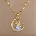 Macro detail of gold moon rabbit pendant necklace featuring sparkling zircon crystals - Gold