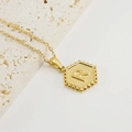 Colgante hexagonal dorado con letra R y borde de milgrain en una cadena fina y sutil - Letra R (Con Cadena de Cruz)