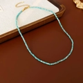 Detailed view of turquoise beaded necklace with golden lobster clasp and extender chain - Blue