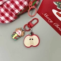 Dettaglio portachiavi natalizio con mela e elfo accanto a borsa in pied-de-poule - Portachiavi Mela Renna Regalo