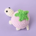 Handmade crochet turtle plush with a pink strawberry shell design and green leaf detail - Purple Strawberry Costume Turtle