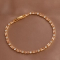 Golden bracelet detail with champagne rectangular gems and round zircons on silk background - Champagne Bracelet