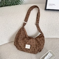 Detailed texture of brown corduroy bag with heart patterns and brand label - Brown