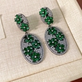 Close-up of vintage flower earrings with green zircon petals and cubic zirconia inlay - Silver Needle - Gun Black - Green