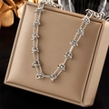 Collier chaîne torsadée en acier titane argenté sur boîte à bijoux, style punk chic - Collier en Argent